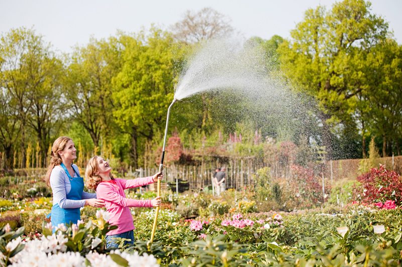 Mother and Daughter Watering Garden